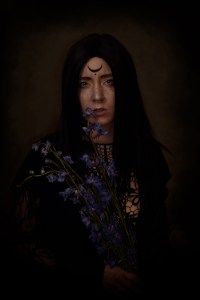 melancholic witch holding flowers