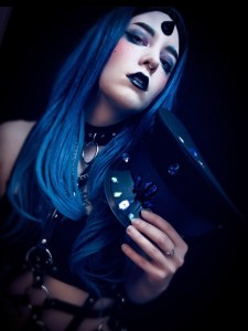 Goth portrait of a femme character with long blue hair and a custom, jeweled rave hat