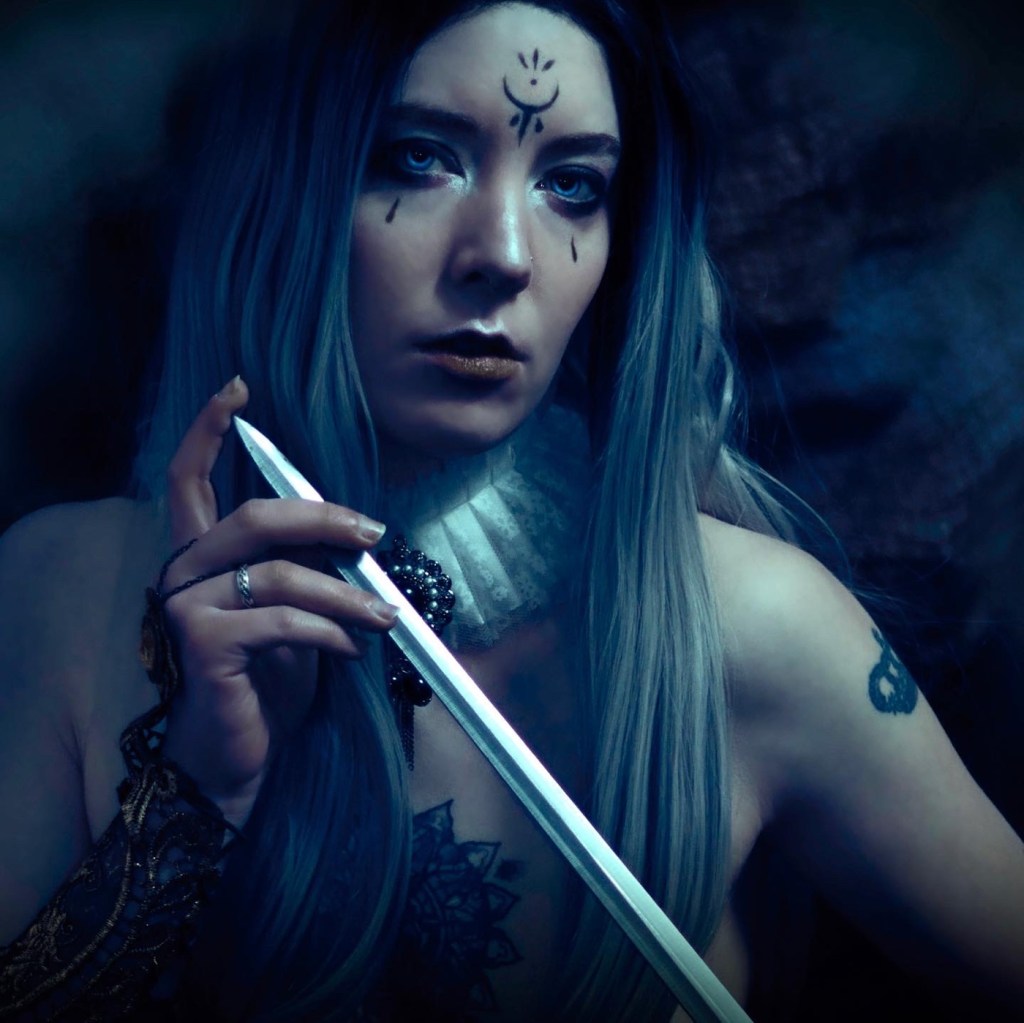 Fantasy and moody boudoir portrait photography of a queen with a sword