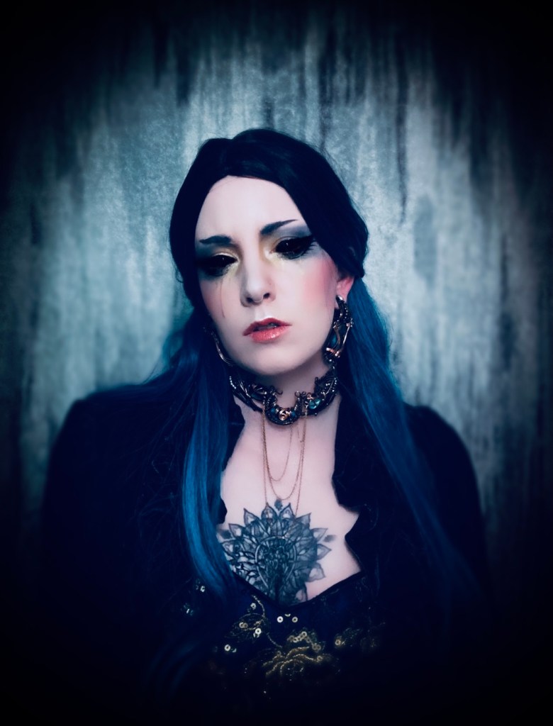 Moody self portrait photo of a model in blue crying gold. Beautiful Custom jewelry made by Nykira Nymph